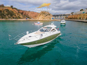 A stunning yacht, 'Infinity 1', glides through clear waters, showcasing its sleek design against a picturesque coastal backdrop — perfect for luxury charters and scenic cruises.