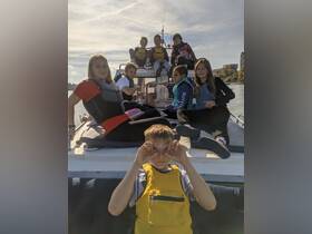 A lively group of children enjoys a day on the boat, showcasing fun and camaraderie while wearing life jackets — perfect for a memorable boating adventure.