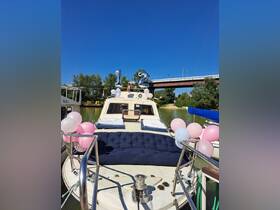 A beautifully decorated boat featuring balloons and a cozy seating area, perfect for celebrations or gatherings on the water.