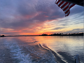 A stunning sunset view from a boat, showcasing vibrant colors reflecting on the water — perfect for serene evening cruises.
