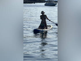 A parent and child enjoy paddleboarding together in calm waters, creating unforgettable family memories on the water.