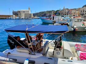 A group enjoys a relaxing moment aboard a boat at the dock, with drinks in hand and picturesque surroundings — perfect for a day of leisure on the water.