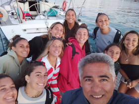 A joyful group of friends poses for a selfie on a boat, capturing the excitement of their adventure together — perfect for memorable outings on the water.