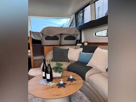 A cozy interior view of a boat's cabin featuring comfortable seating and a stylish table setup, perfect for relaxation and socializing on the water.