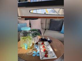 A beautifully arranged table featuring refreshing cocktails and gourmet snacks, perfect for entertaining guests in the cozy interior of a yacht.