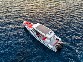 Aerial view of a sleek speedboat cruising through calm waters, showcasing its stylish design and spacious seating — perfect for day trips and water adventures.