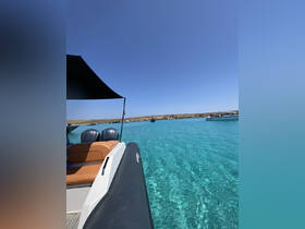 A sleek boat glides through crystal-clear waters, showcasing the stunning scenery of a sunlit coastline — perfect for exploring beautiful destinations.