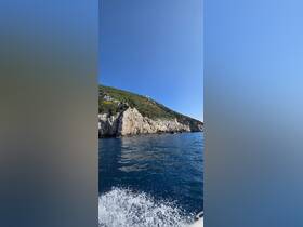 A stunning view of a rugged coastline and lush greenery, showcasing the natural beauty of the area — perfect for scenic boat tours.