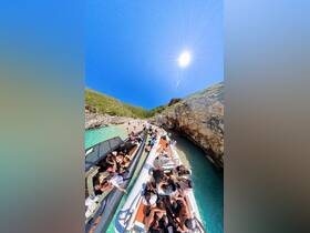 A vibrant scene of a group enjoying a beach day with multiple boats anchored nearby, showcasing the fun and excitement of a sunny outing on the water.