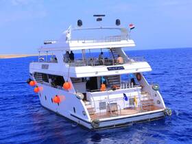 A stunning yacht named 'Sea Life' navigates the vibrant blue waters, with guests enjoying the scenic views — perfect for a luxurious day on the water.