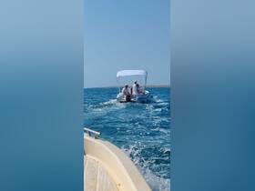 A small boat with three people enjoying a cruise on clear blue waters, showcasing the fun of on-water adventures.