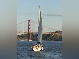 A beautiful sailboat named 'Little One' glides through the water with the iconic bridge in the background, showcasing a perfect day for sailing.