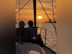 A couple enjoys a romantic sunset view from the deck of a yacht, creating a perfect backdrop for memorable sunset cruises.