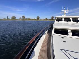 A stunning side view of a yacht cruising on calm waters, showcasing its sleek design and beautiful surroundings.