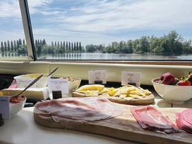 A beautifully arranged charcuterie spread featuring various salads, meats, and fresh strawberries, perfect for enjoying on a boat while taking in scenic views.