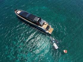 A stunning aerial view of a luxurious yacht cruising through crystal-clear waters, showcasing its sleek design and accompanying water toys.
