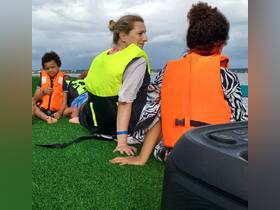 A family enjoys a fun day on the water, wearing life jackets while seated on a boat — perfect for safe aquatic adventures.