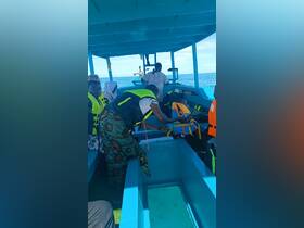 Passengers aboard a boat prepare for their journey, showcasing the interior setup and safety gear. A child is visible, adding to the family-friendly atmosphere.