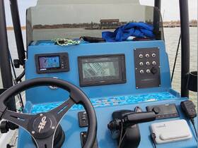 A detailed view of the helm and console of a boat, showcasing the navigation equipment and controls essential for steering and monitoring during a trip.