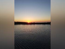 A stunning sunset over calm waters, creating a picturesque scene perfect for evening boat trips or relaxation by the shore.
