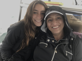 Two smiling women pose together on a boat, capturing a joyful moment during their maritime adventure.