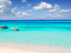 A serene view of speedboats anchored in crystal-clear turquoise waters, perfect for exploring the beautiful coastline.