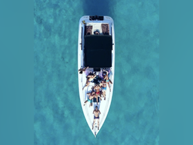 An aerial view of a lively group enjoying their time on a boat in clear turquoise waters, perfect for summer parties and fun on the water.
