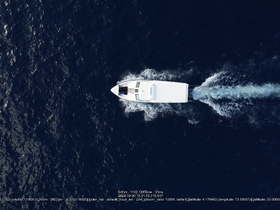 Aerial view of a sleek speedboat cruising through deep blue waters, showcasing the vessel's design and performance.