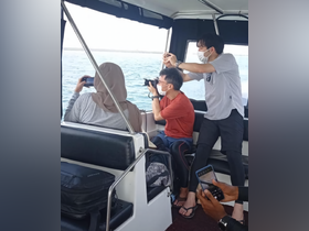 Guests capture the scenic views from inside the boat, showcasing the comfortable seating and relaxed atmosphere perfect for sightseeing on the water.
