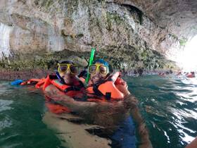 A couple enjoys snorkeling in a stunning cave, showcasing the beauty of underwater adventures — perfect for thrill-seekers and nature lovers.