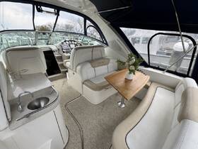 A cozy interior view of a boat's cabin featuring comfortable seating and a well-equipped helm, perfect for relaxing or navigating on the water.