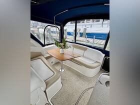 A cozy interior view of a boat's cabin featuring comfortable seating and a dining table, perfect for relaxing and enjoying meals while on the water.