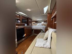 A cozy interior view of a boat cabin featuring comfortable seating and a well-equipped kitchen area, perfect for relaxing and enjoying time on the water.