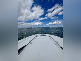 A stunning view from the front of a yacht cruising through calm waters, showcasing the beautiful sky and distant shoreline.
