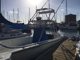 A sleek boat docked at the marina, surrounded by masts and other vessels, showcasing the perfect setting for a day on the water.