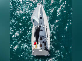 Aerial view of a sailboat navigating through sparkling turquoise waters, showcasing the excitement of sailing adventures on the open sea.