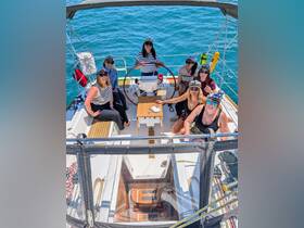 A lively group of friends enjoys a sailing adventure, celebrating together on the deck of a yacht — perfect for memorable outings and gatherings on the water.