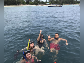 A lively group enjoys snorkeling in clear waters, showcasing the excitement of underwater adventures and group fun.