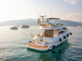 A stunning yacht anchored in serene waters, showcasing its elegant design against a backdrop of distant mountains — perfect for luxury getaways.