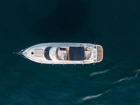 Aerial view of a sleek yacht gliding through deep blue waters, showcasing its elegant design and spacious deck, perfect for luxury cruising.