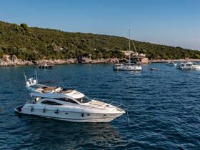 A stunning yacht anchored in calm waters, surrounded by a picturesque coastline, perfect for exploring the beautiful scenery.