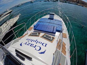 A stunning aerial view of the 'Crazy Dolphin' yacht docked in crystal-clear waters, showcasing its spacious deck and inviting lounging area.