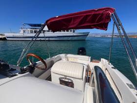 A view of the helm and seating area inside a boat, showcasing the steering wheel and console, perfect for a day on the water.
