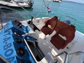 Interior view of a boat's helm and seating area, showcasing the controls and comfortable seating, ideal for a day on the water.