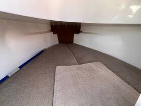 Interior view of a cozy boat cabin featuring comfortable seating, ideal for relaxation during trips on the water.