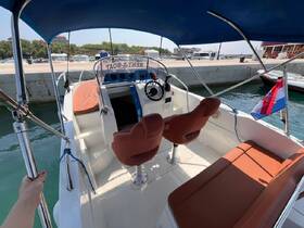 Interior view of a rental boat's helm and seating area, showcasing comfortable seating and a well-equipped dashboard, perfect for a day on the water.