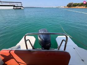 A view from the back of a motorboat, showcasing the engine and tranquil turquoise waters, perfect for a day of exploration on the water.