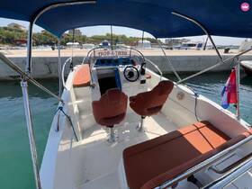 Interior view of a boat's helm and seating area, showcasing comfortable seating and a well-equipped control panel, perfect for a day on the water.