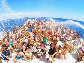 A vibrant party scene aboard a boat with a lively crowd enjoying drinks and splashing water, perfect for unforgettable summer celebrations on the water.