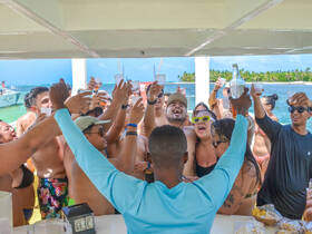 A lively group celebrates with drinks on a boat, capturing the essence of fun and camaraderie during a memorable party at sea.